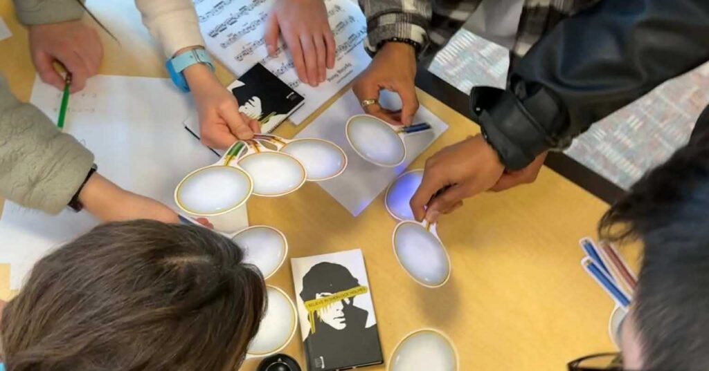 Teens playing a Sherlock Holms escape room game using UV reveal at a library.
