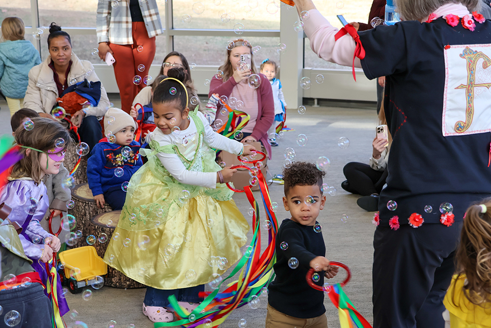 kids from the Little Leapers program playing with bubbles and dressed up as princesses and superhero's